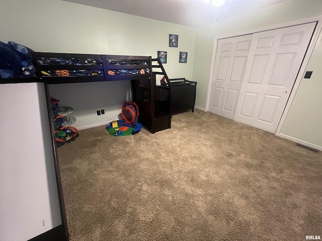 bedroom featuring a closet, carpet flooring, baseboards, and visible vents