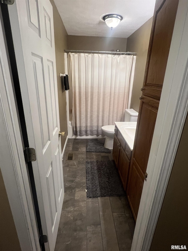 full bath featuring toilet, vanity, shower / bath combo with shower curtain, and visible vents