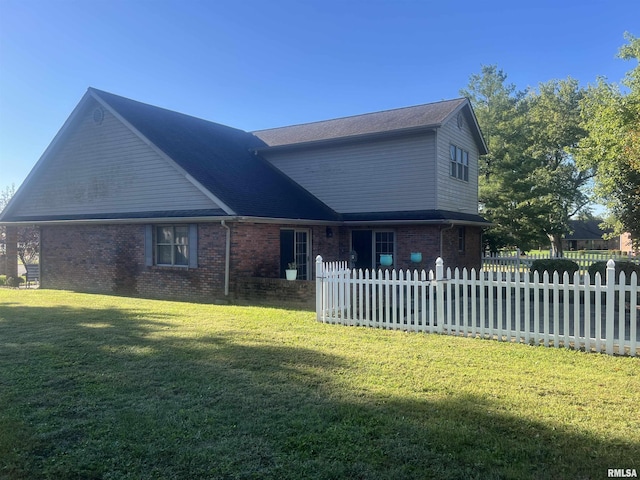 view of front facade with brick siding, a front lawn, and a fenced front yard