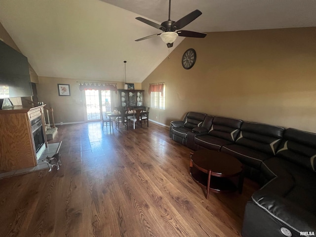 living room with ceiling fan, vaulted ceiling, and wood-type flooring