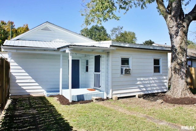 rear view of property featuring a porch and a lawn