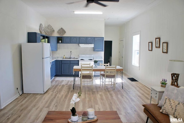 kitchen with white appliances, blue cabinets, light hardwood / wood-style flooring, and sink