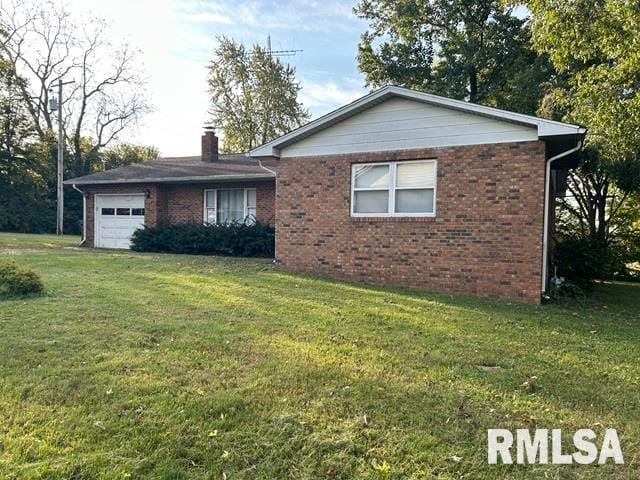 view of front of home with a front yard and a garage