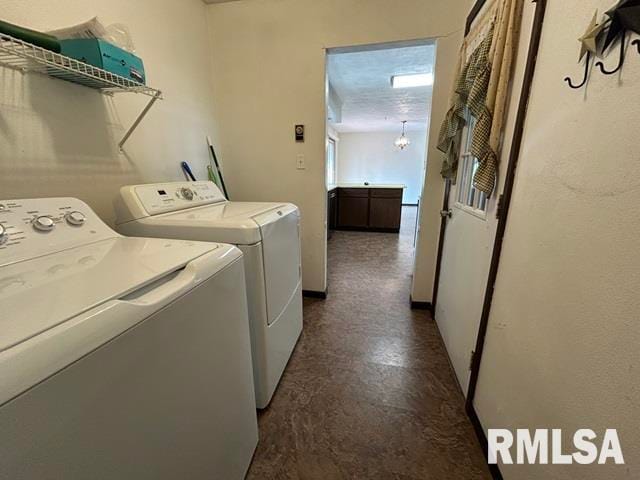 clothes washing area featuring independent washer and dryer and a chandelier