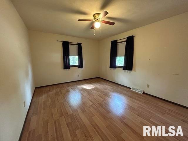 spare room with light wood-type flooring and ceiling fan