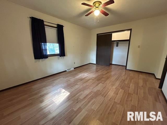 unfurnished bedroom featuring ceiling fan, light wood-type flooring, and a closet