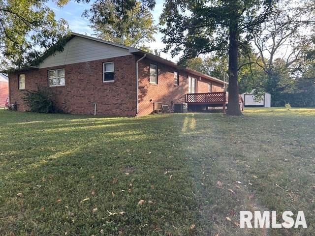 view of side of property featuring a deck and a lawn