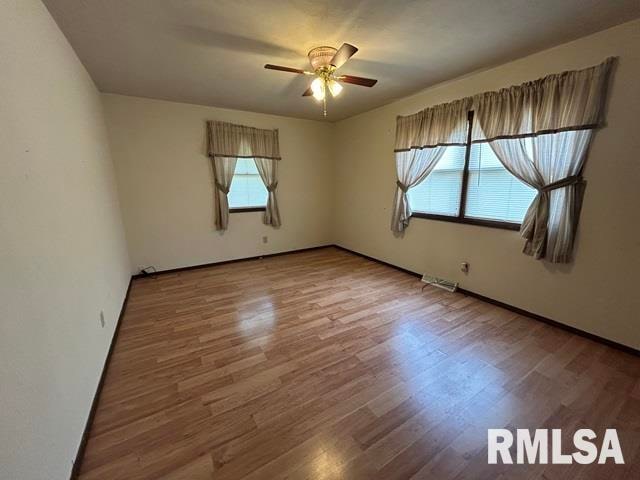 unfurnished room with hardwood / wood-style floors and ceiling fan