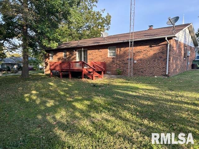 rear view of property featuring a yard and a deck