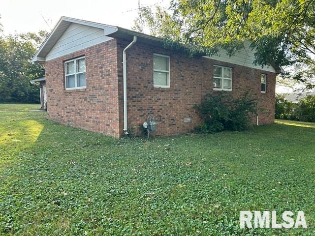 view of side of home with a lawn