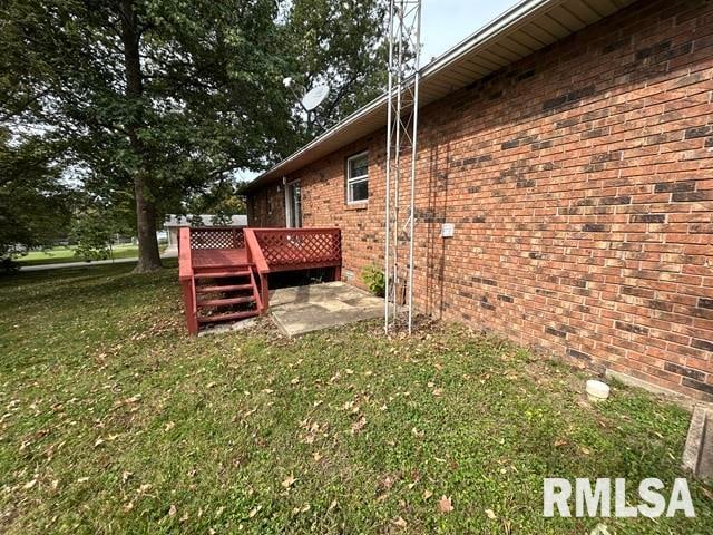 view of side of home with a yard and a deck