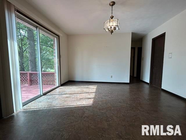 unfurnished room featuring a notable chandelier