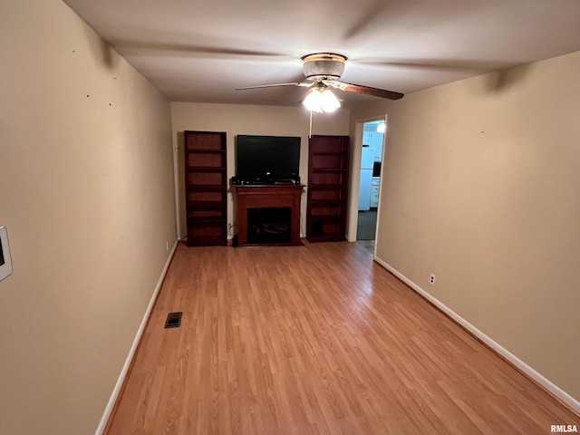 unfurnished living room featuring ceiling fan and light wood-type flooring