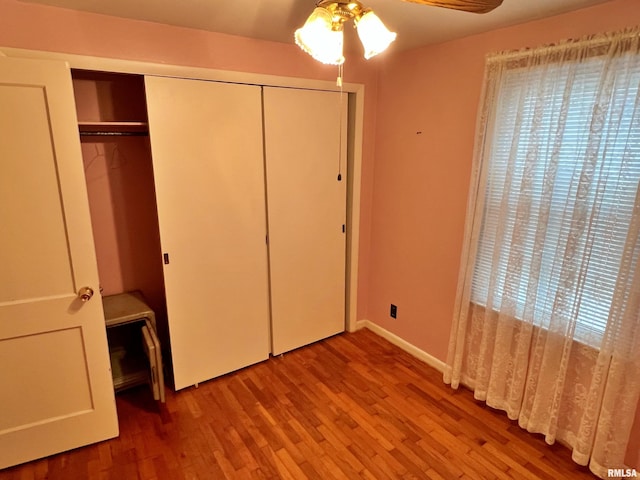 unfurnished bedroom with a closet, hardwood / wood-style floors, and ceiling fan