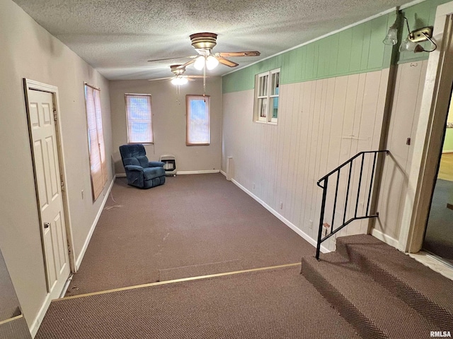 unfurnished room featuring a textured ceiling, wood walls, and carpet flooring