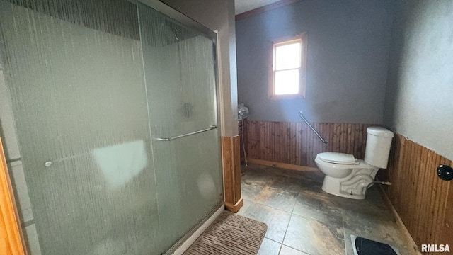 bathroom with wooden walls, a shower with shower door, and toilet