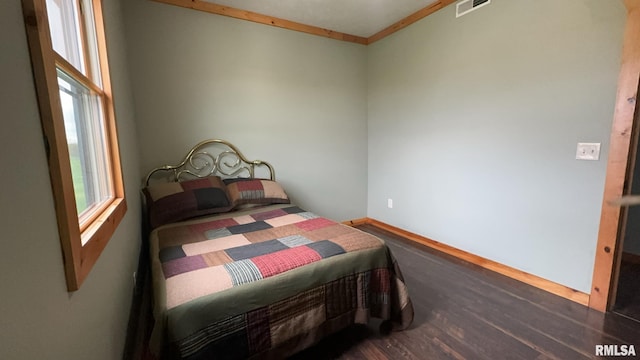 bedroom featuring ornamental molding and dark hardwood / wood-style flooring