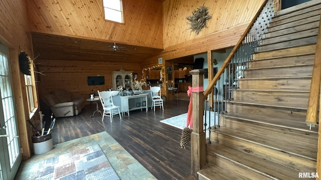 stairway with wood-type flooring, wooden walls, and plenty of natural light