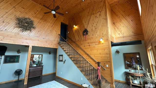 staircase featuring high vaulted ceiling, hardwood / wood-style flooring, wooden walls, and ceiling fan