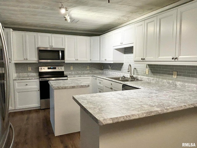 kitchen with sink, white cabinetry, appliances with stainless steel finishes, dark hardwood / wood-style flooring, and decorative backsplash