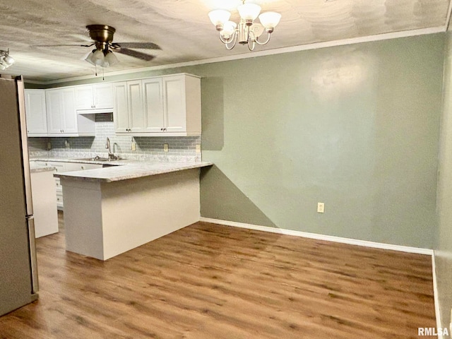 kitchen featuring kitchen peninsula, light wood-type flooring, sink, and white cabinets