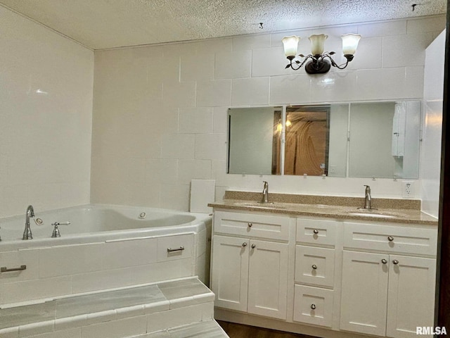 bathroom featuring hardwood / wood-style floors, a washtub, vanity, and a textured ceiling