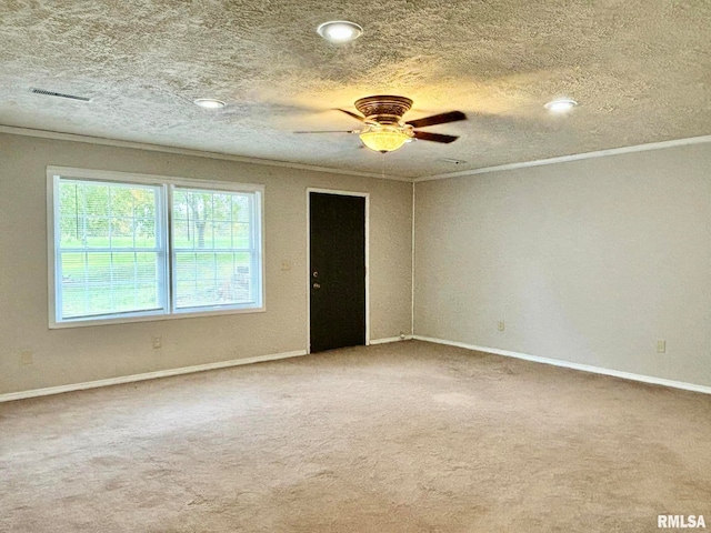 carpeted empty room featuring ceiling fan, a textured ceiling, and crown molding