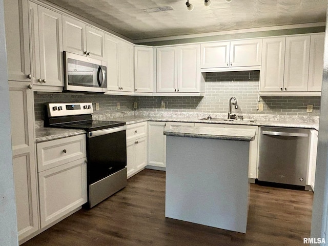 kitchen featuring a kitchen island, sink, stainless steel appliances, dark hardwood / wood-style floors, and white cabinets