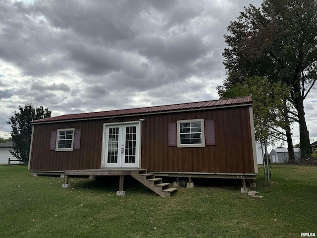 rear view of property featuring french doors and a lawn