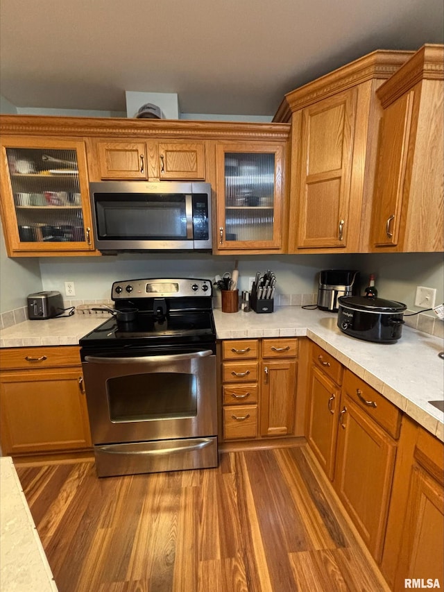 kitchen with stainless steel appliances and hardwood / wood-style flooring