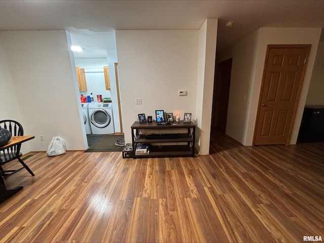 living room with washer and dryer and wood-type flooring