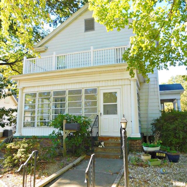 view of front facade with entry steps and a balcony