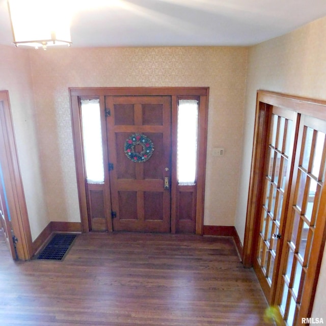 foyer entrance with french doors and dark hardwood / wood-style flooring