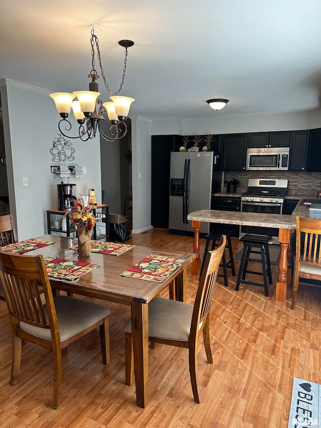 dining space with crown molding and a notable chandelier