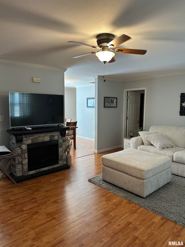 living room featuring crown molding, hardwood / wood-style flooring, and a fireplace