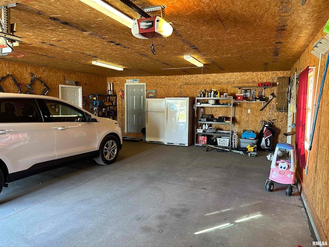 garage featuring a garage door opener and white refrigerator