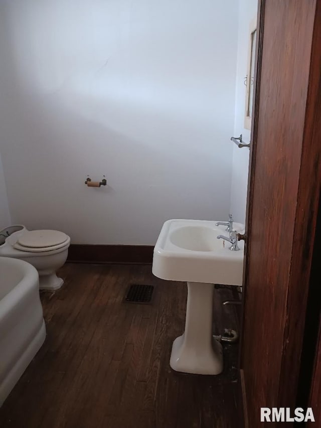 bathroom with toilet and wood-type flooring