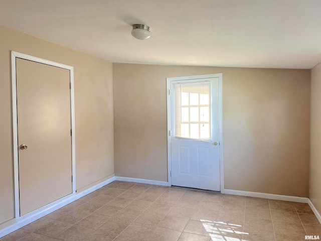 doorway to outside featuring lofted ceiling and light tile patterned floors