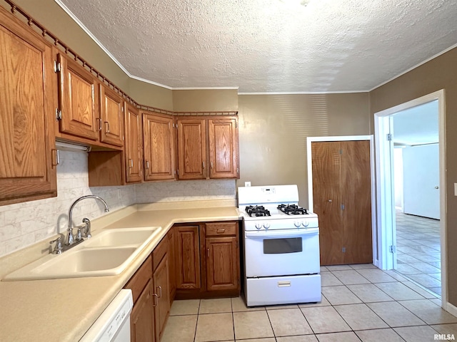 kitchen with white appliances, light tile patterned flooring, sink, a textured ceiling, and decorative backsplash