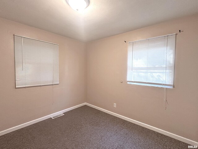 1911 Wall St, Murphysboro, IL 62966 - unfurnished room featuring baseboards, visible vents, and dark carpet