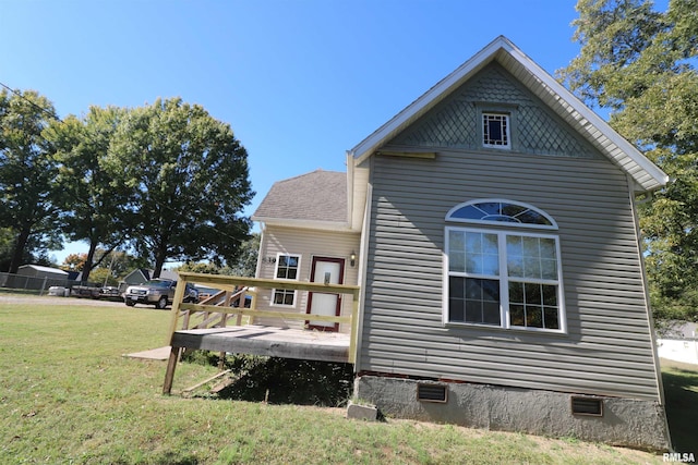 view of home's exterior featuring a deck and a lawn