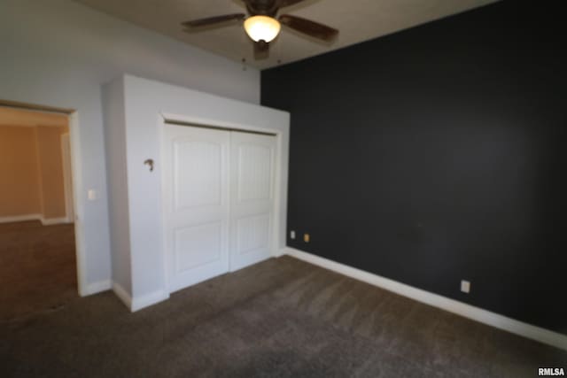 unfurnished bedroom with a closet, dark carpet, and ceiling fan