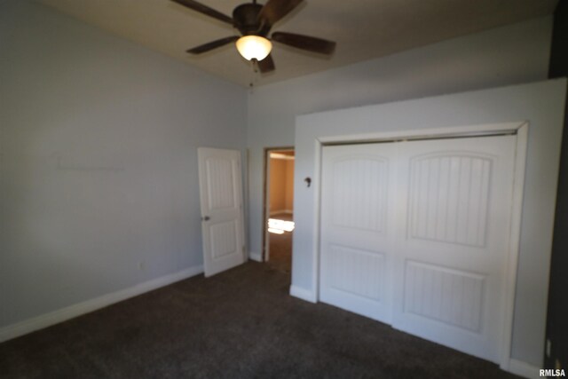 unfurnished bedroom with dark colored carpet, a closet, and ceiling fan