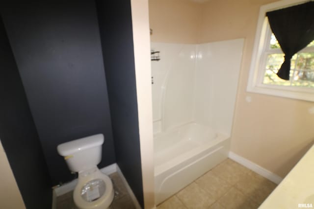 bathroom featuring toilet, shower / bathing tub combination, and tile patterned flooring