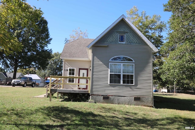 back of property with a wooden deck and a yard