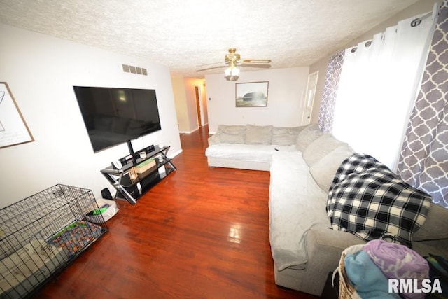 living room with ceiling fan, hardwood / wood-style floors, and a textured ceiling