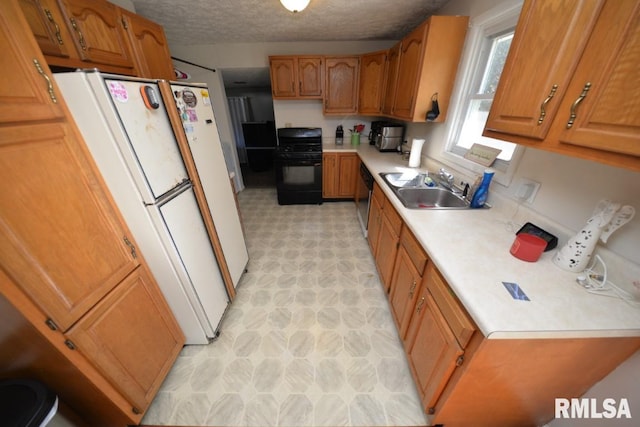 kitchen featuring dishwasher, stove, sink, a textured ceiling, and white fridge