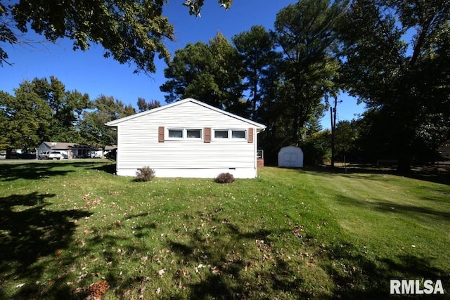 view of side of property with a lawn and a storage unit