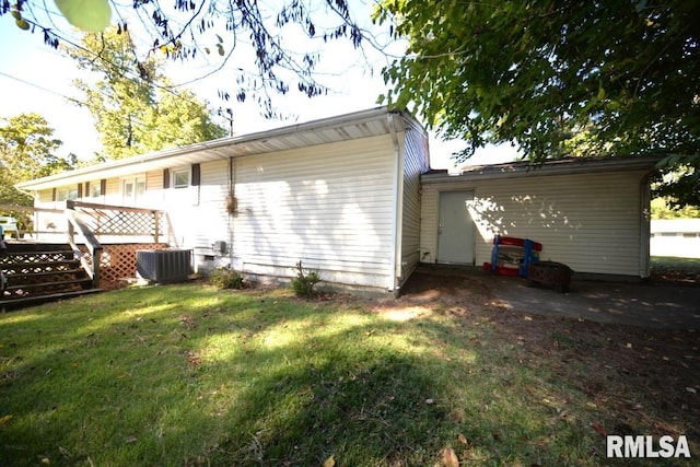 rear view of property with a yard, central AC, and a wooden deck