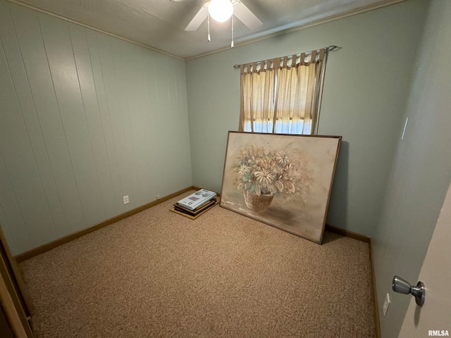 unfurnished room with wood walls, a textured ceiling, carpet flooring, and ceiling fan